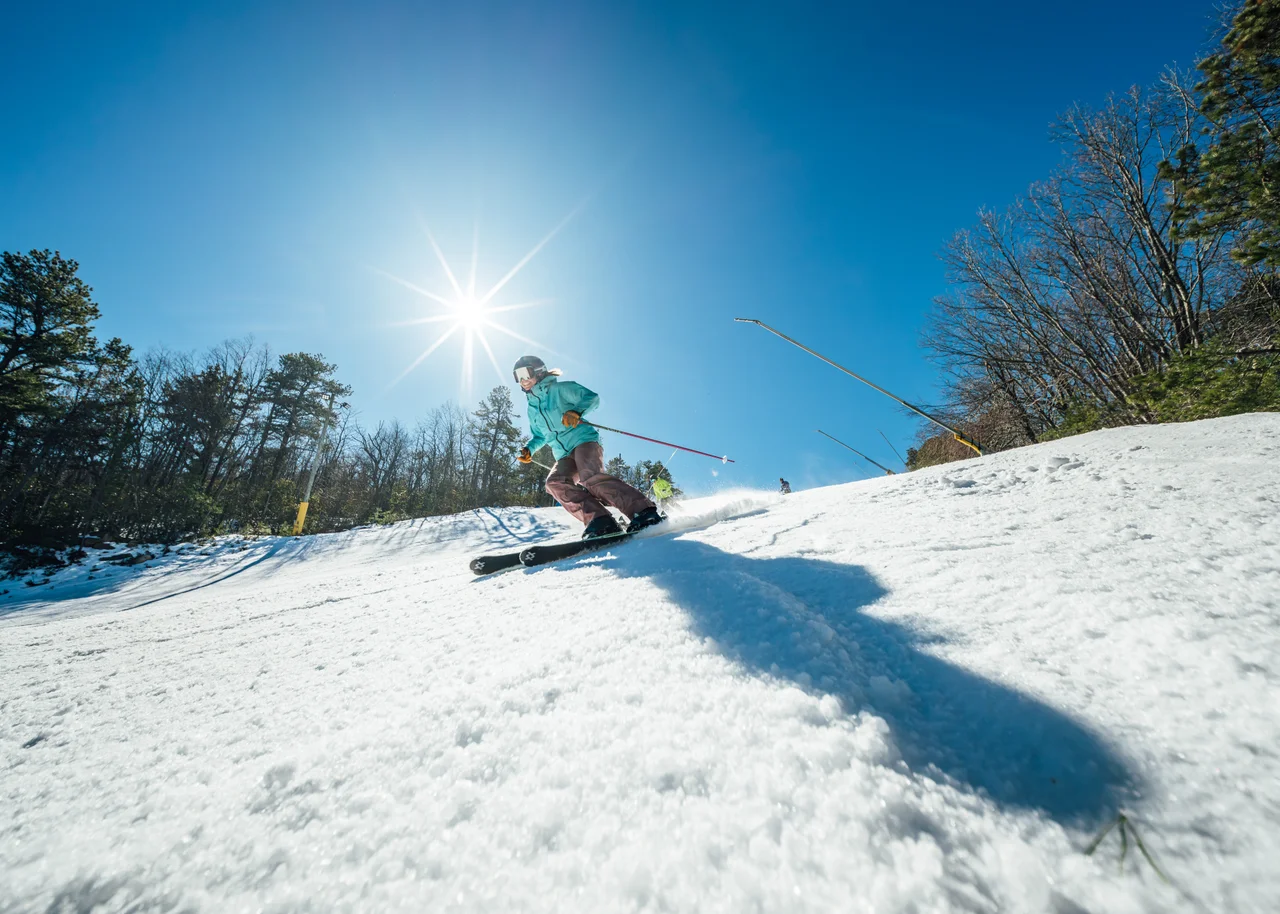 Massanutten ski area general skier carving sunny snowy slope 09