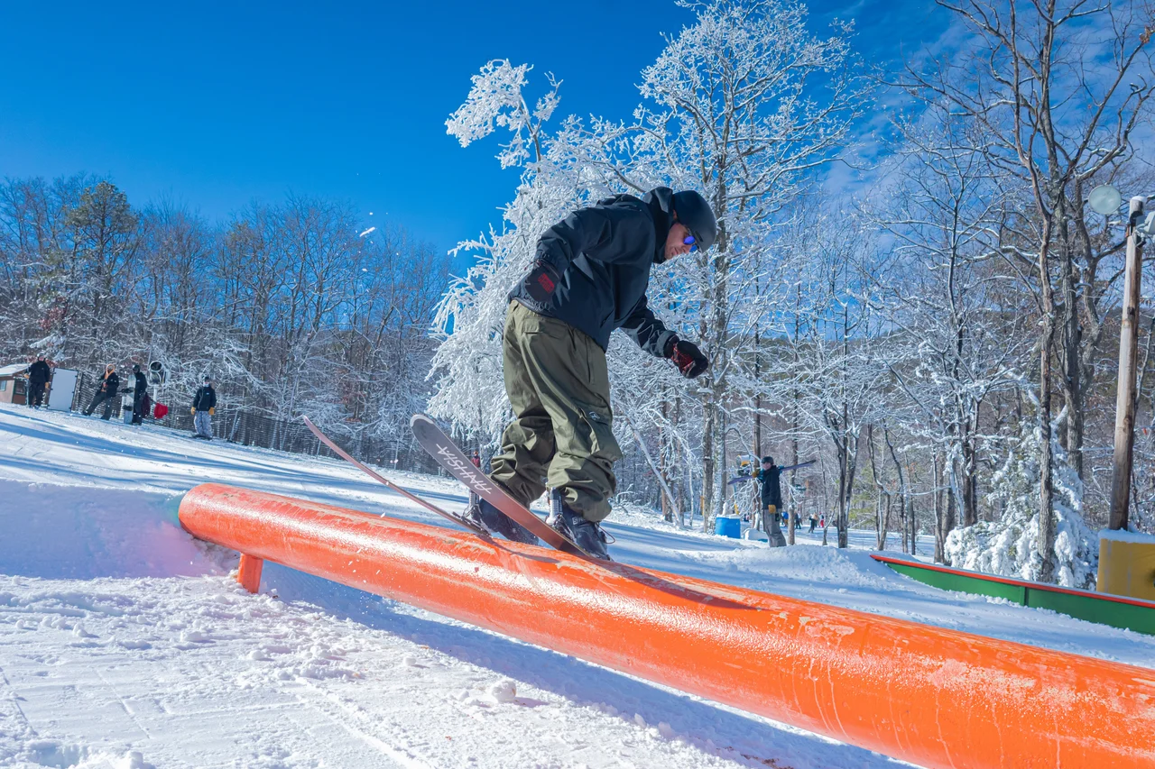 Massanutten ski area terrain park terrain park snowboarder on green rail 06