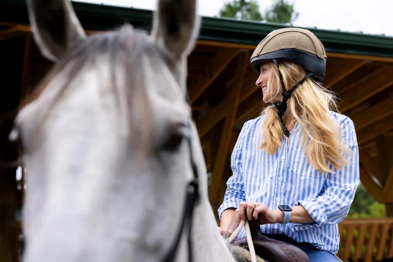 Massanutten horseback riding woman striped shirt gray horse side view