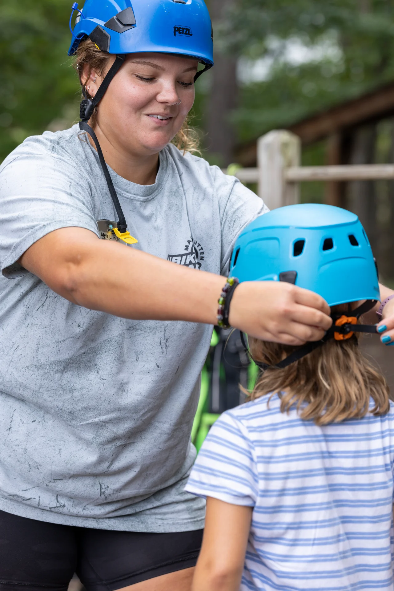 Massanutten kids adventure course instructor adjusting girls blue climbing helmet