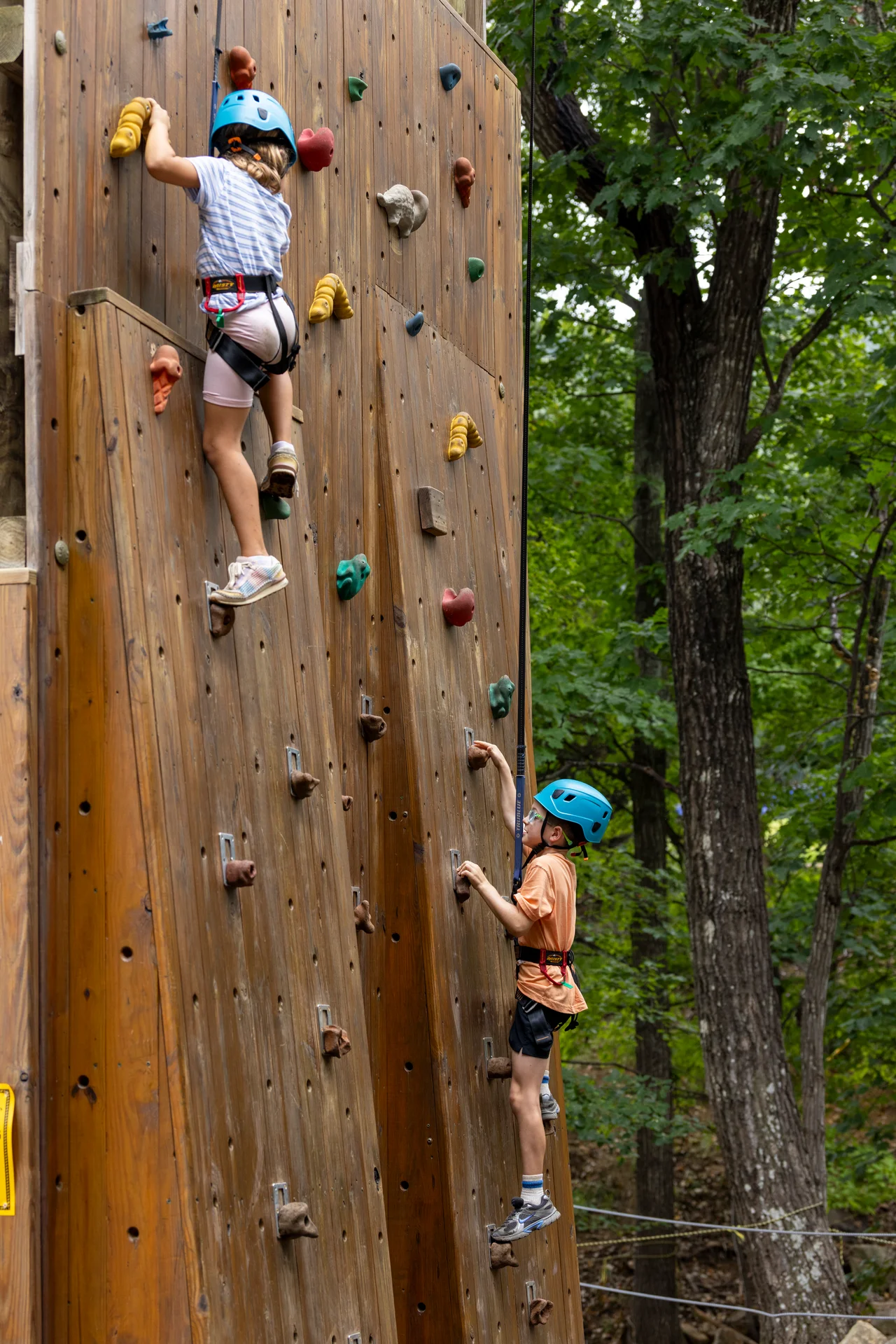 Massanutten kids adventure course two children climbing wooden wall blue helmets